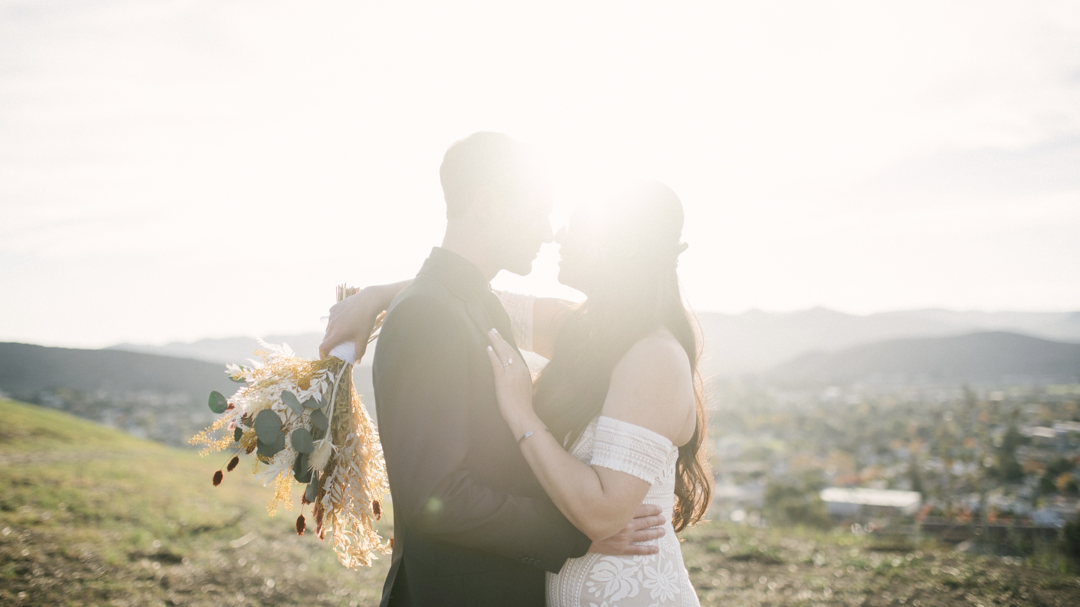 Image of a couple at their wedding on the top of a hill.